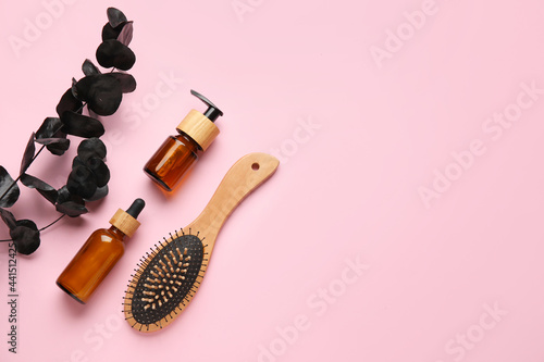 Fototapeta Naklejka Na Ścianę i Meble -  Hair brush and bottles of cosmetic products on color background