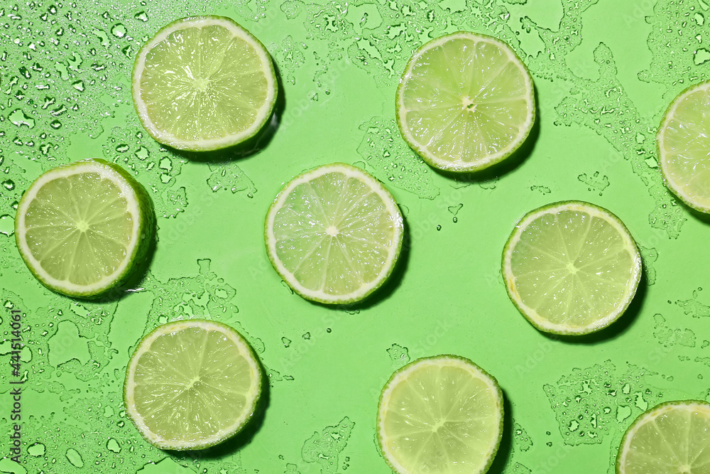 Slices of ripe lime on color background with water drops Slices of ripe lime on color background with water drops