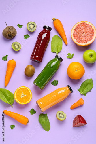 Bottles of healthy smoothie and ingredients on color background