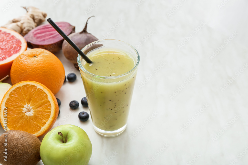 Glass of healthy smoothie and ingredients on light background Glass of healthy smoothie and ingredients on light background