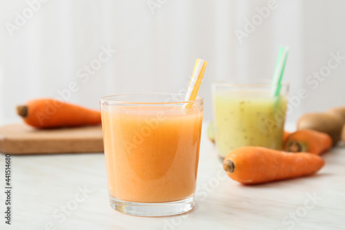 Glasses of healthy smoothie with kiwi and carrot on light background