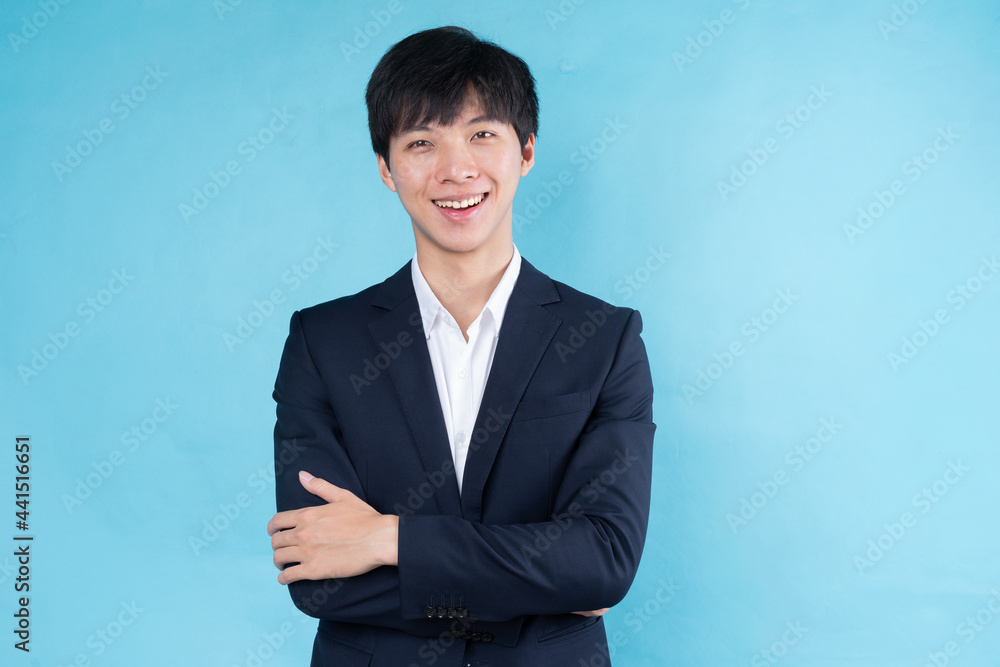 Image of young Asian businessman wearing a suit on a blue background Image of young Asian businessman wearing a suit on a blue background