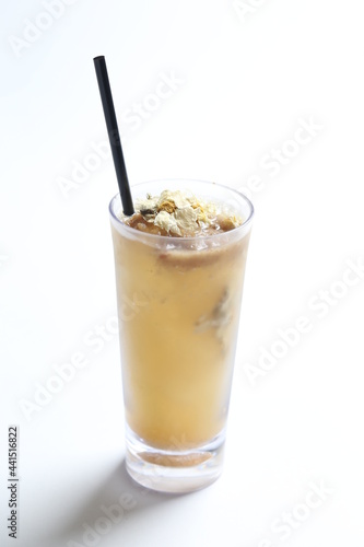 homemade cook ice cold chilled yellow Chrysanthemum flower tea in tall glass white background beverage menu