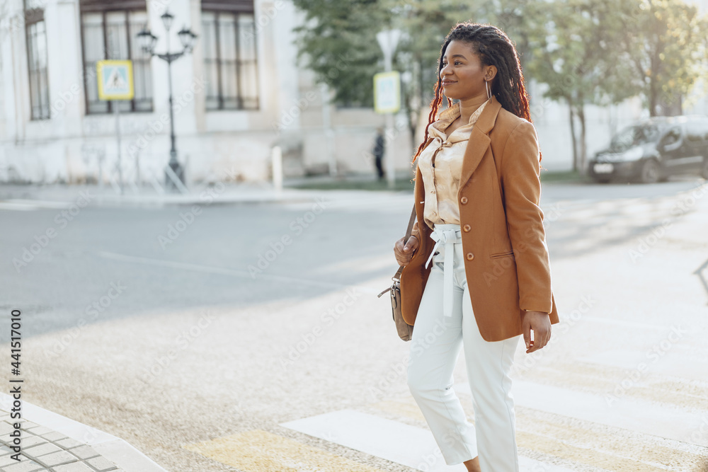 Fototapeta premium Young african american woman crossing the street