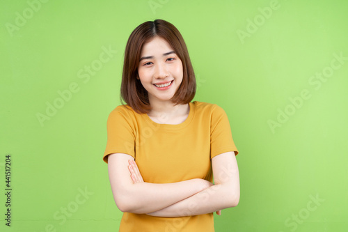 Young asian girl posing on green background