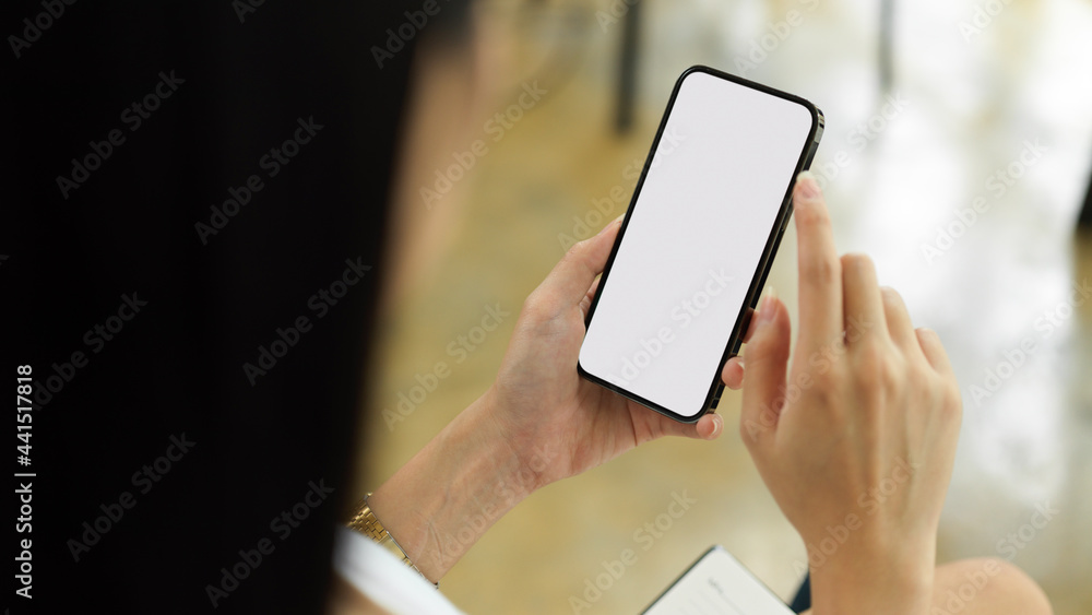 Wunschmotiv: Over shoulder close up view of female using smartphone with mock-up screen #441517818
