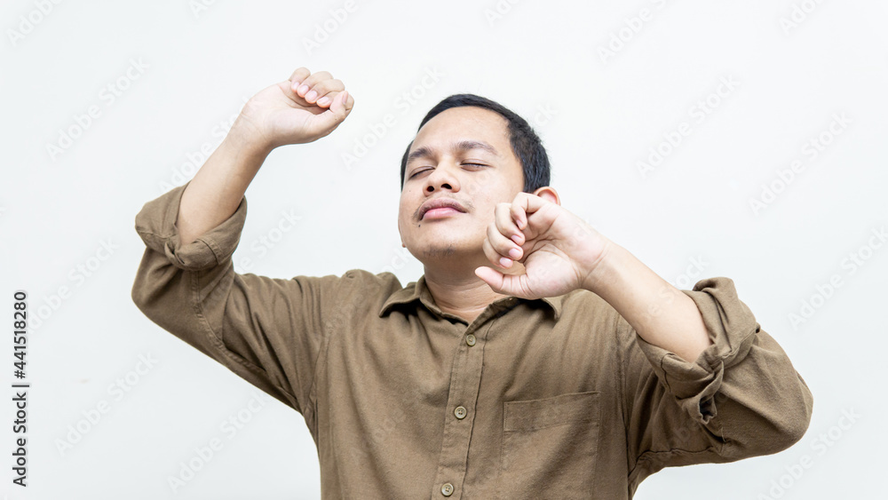 Happy and excited face expression of young Asian Malay man dancing and feeling the beat of the music on isolated white backgrounds. Cheerful, smiling moving casual and confident listening to music. Happy and excited face expression of young Asian Malay man dancing and feeling the beat of the music on isolated white backgrounds. Cheerful, smiling moving casual and confident listening to music.
