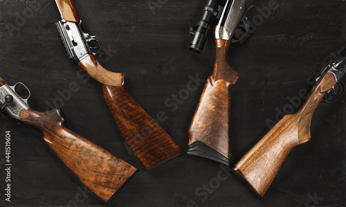 Wooden handle of hunting rifle on dark wooden background