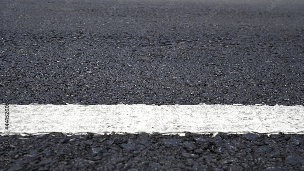 Fototapeta premium Surface rough of asphalt, Grey with white line on grainy road, Texture Background, Close up