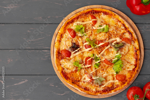 Delicious pizza on gray wooden background top view