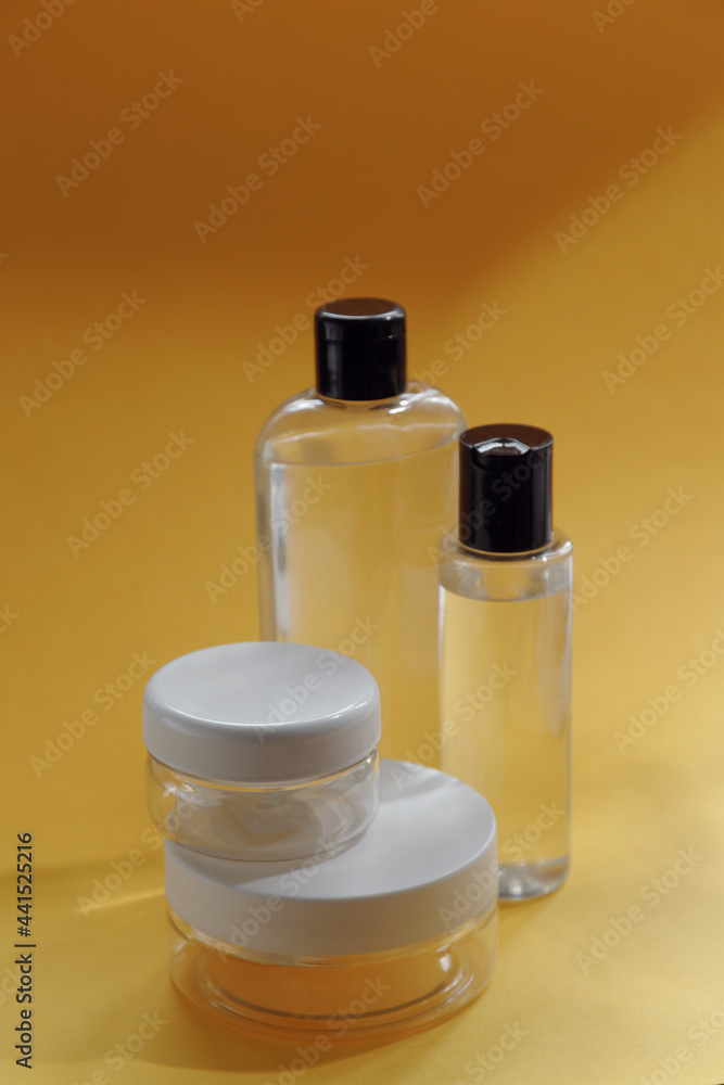 A set of eco-friendly natural cosmetics on a yellow background. Glass transparent bottles, a beautiful composition with an empty space for the text. A set of eco-friendly natural cosmetics on a yellow background. Glass transparent bottles, a beautiful composition with an empty space for the text.