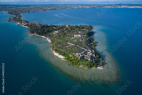 Aerial view of the Grotte di Catullo Ruins at high altitude. Lake Garda, Italy. Olive grove and archaeological museum. Grottoes ruins on the Sirmione peninsula.
