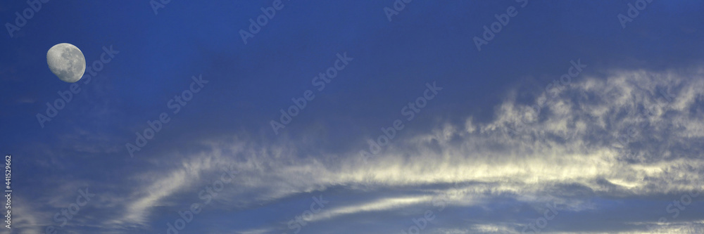 Obraz premium Magnificent white Altostratus cloud in a blue sky with a waning moon. Australia.
