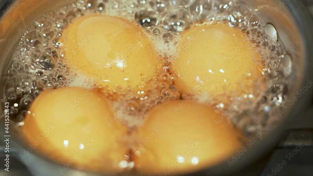 Close-up of Boiling 4 Chicken Eggs in a Saucepan. Slow Motion. Macro Chicken Eggs Are Boiled in Water in a Saucepan. Cooking Healthy Food. Cooking a Healthy Breakfast of 4 Eggs. Close-up of Boiling 4 Chicken Eggs in a Saucepan. Slow Motion. Macro Chicken Eggs Are Boiled in Water in a Saucepan. Cooking Healthy Food. Cooking a Healthy Breakfast of 4 Eggs.