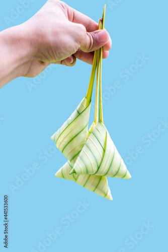 Glutinous rice wrapped with leaves on blue background. Also known as Ketupat Palas. Served during eid festival by Muslim.
