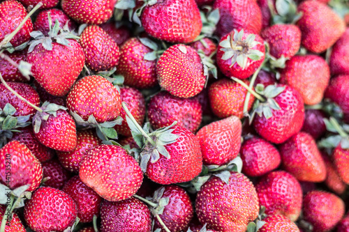 Red ripe strawberries background. Close up, top view. Close-up of a pile of ripe strawberries.