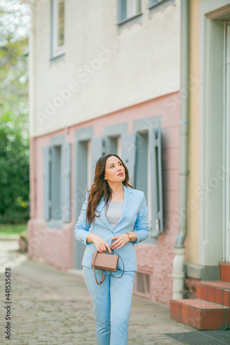 Portrait of a beautiful young woman in a blue suit with a bouquet of tulips. Spring.