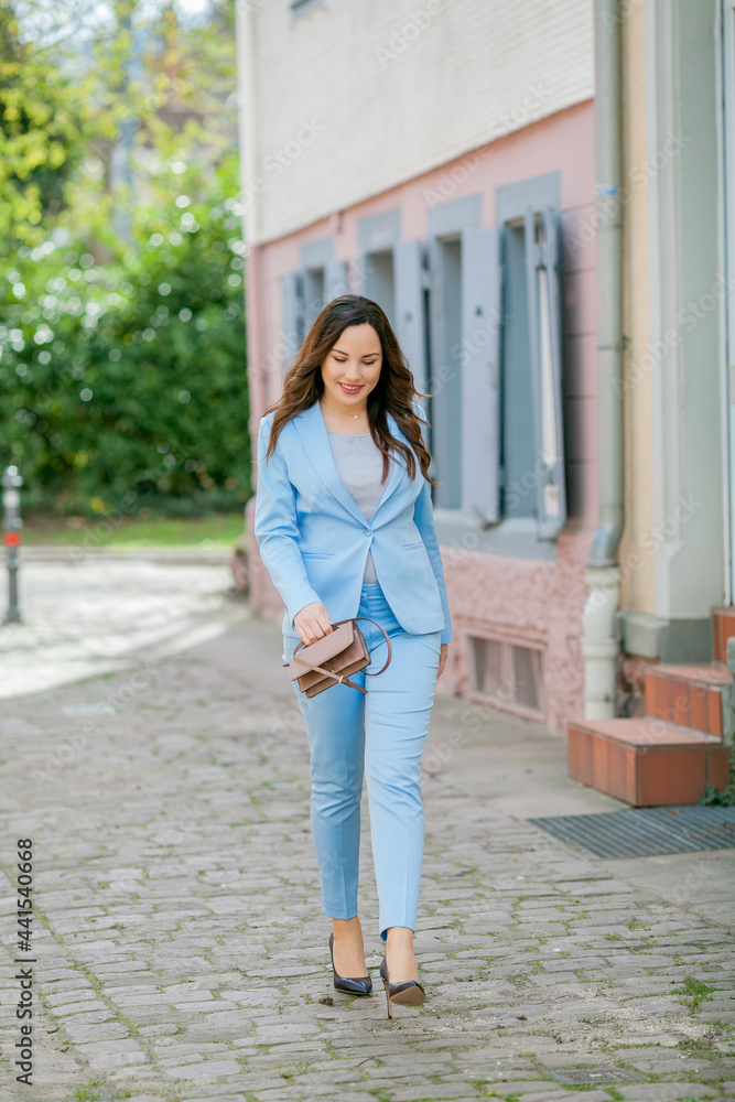 Portrait of a beautiful young woman in a blue suit with a bouquet of tulips. Spring. Portrait of a beautiful young woman in a blue suit with a bouquet of tulips. Spring.