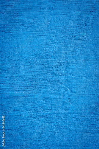 Rough textured bright blue painted concrete surface for backgrounds and design concepts