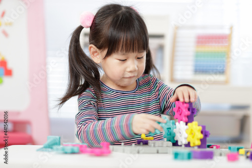 young girl plays creative gear blocks for home schooling