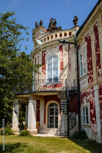 Baroque castle Steknik, stucco, peeling dark red plaster, red tile roof, green lawn, italian garden, aristocratic residence in summer sunny day, ancient chateau Steknik, Czech Republic, June 19 2021 photo