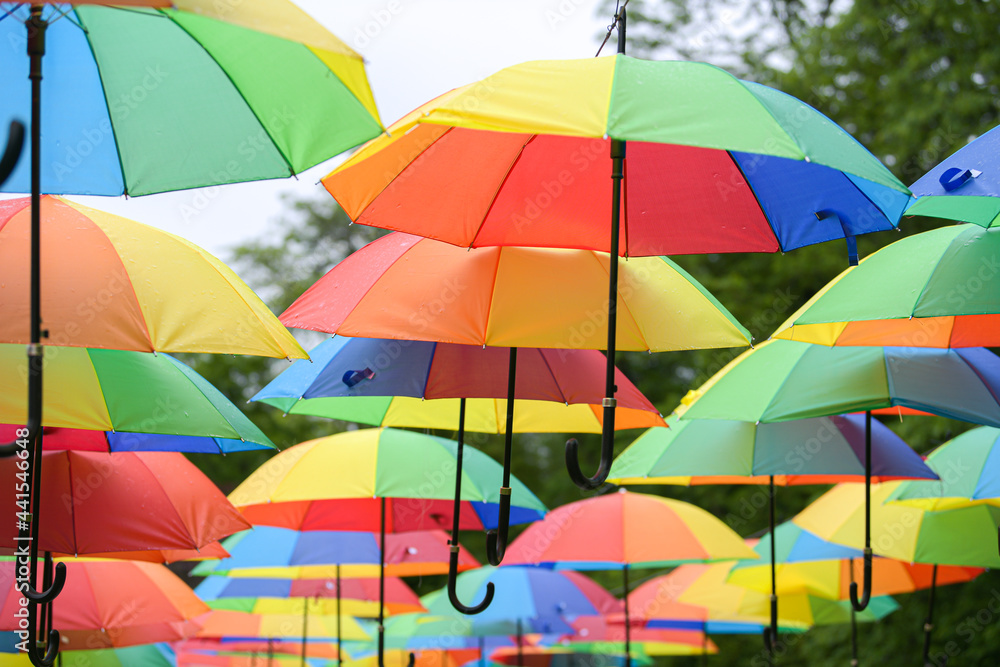 A lot of umbrellas hanged in a park. Beautiful view with a lot of color. Vivid photo.
