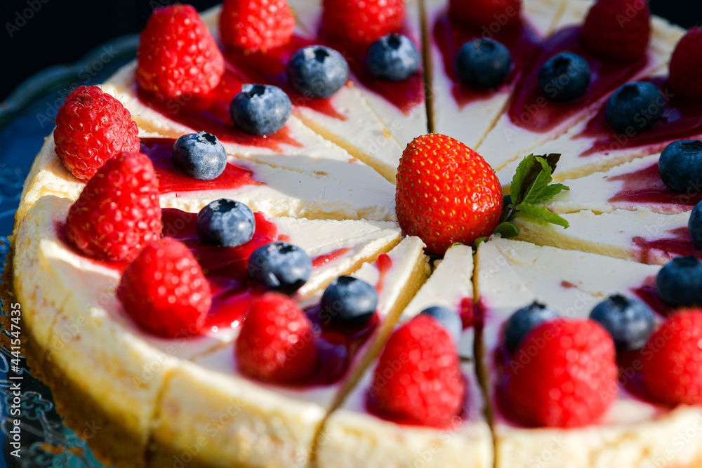 Close up view of a delicious cheesecake ready to be served as a desert with forest fruits on top of it. Close up view of a delicious cheesecake ready to be served as a desert with forest fruits on top of it.