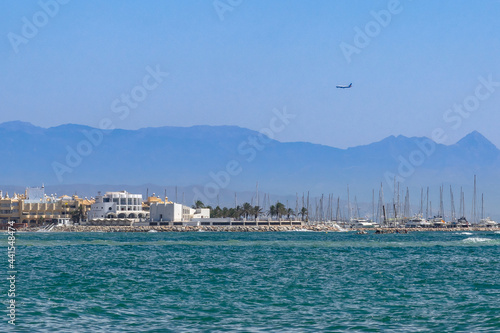 A turquoise sea in sunny sparks on a sunny day. Small boat on the water. Alboran Sea in Benalmadena. Andalusia, Spain.