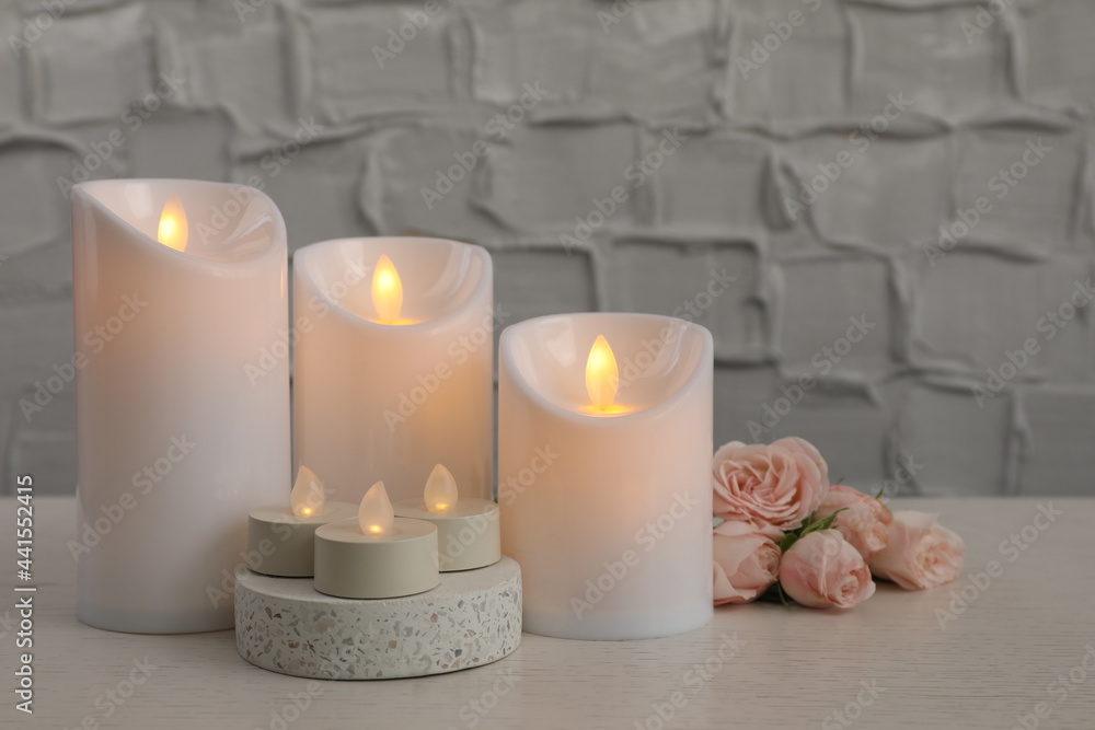 Decorative LED candles on white wooden table Decorative LED candles on white wooden table