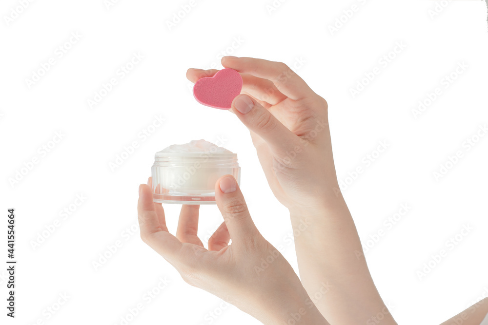 moisturizer on a white background, female hands hold cosmetics, skin care, pink heart-shaped sponge, apply cream to the skin moisturizer on a white background, female hands hold cosmetics, skin care, pink heart-shaped sponge, apply cream to the skin