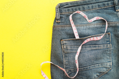 blue jeans with measure tape in pocket in form of a heart. concept of healthy lifestyle and diet with love to your body