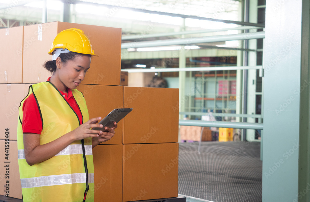 Concept of work in logistic, industry, factory. African worker in helmet Checks Stock and Inventory with Digital Tablet. 