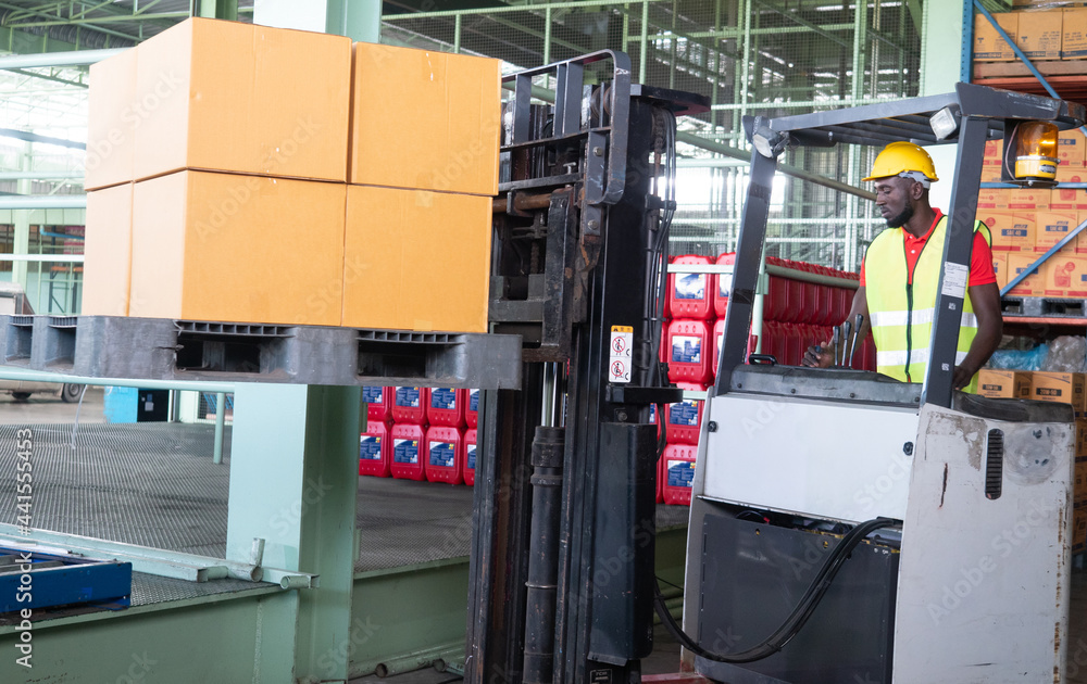 Professional African America worker using forklift machine in storehouse. Professional African America worker using forklift machine in storehouse.