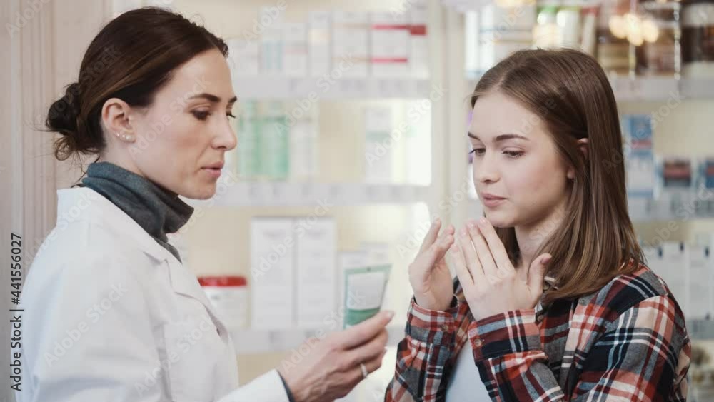 A professional pharmacist is explaining how to use a medical cream to a client in a pharmacy A professional pharmacist is explaining how to use a medical cream to a client in a pharmacy