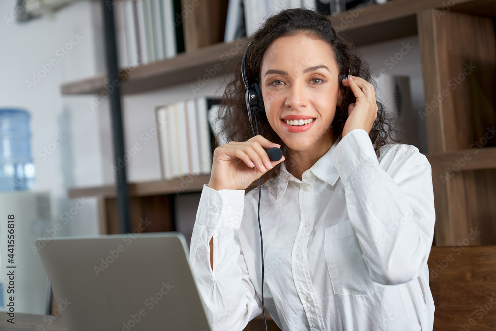 Smiling call center agent latin beautiful woman working on support hotline in co working space Smiling call center agent latin beautiful woman working on support hotline in co working space