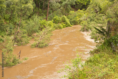 Brown muddy water flowing down the river, southern Sydney highlands