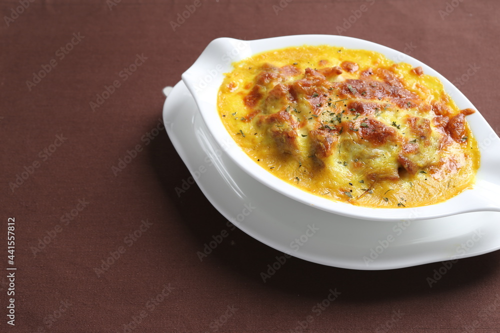 oven baked creamy cheese Japanese curry pasta with chicken in bowl western chef cuisine seafood menu in white and brown background