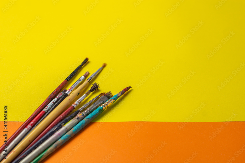 brushes and roller to paint on smooth orange and yellow background brushes and roller to paint on smooth orange and yellow background