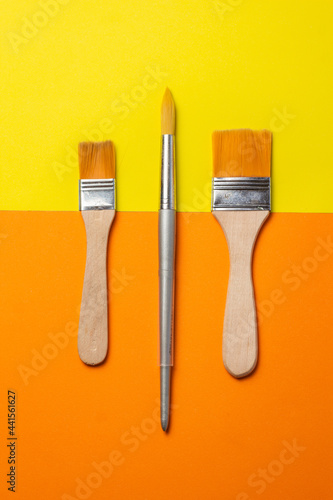 brushes and roller to paint on smooth orange and yellow background