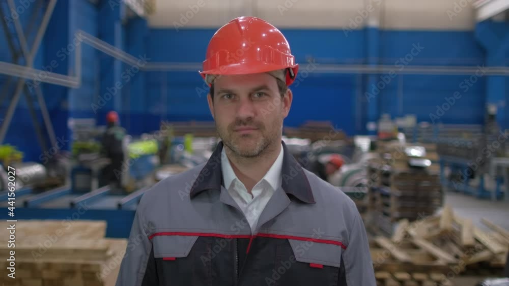 Portrait of professional worker engineer man in hard hat, engineering manufacture plant factory indoors looking at camera. Worker hardhat working on production line in modern manufacturing Industry Portrait of professional worker engineer man in hard hat, engineering manufacture plant factory indoors looking at camera. Worker hardhat working on production line in modern manufacturing Industry