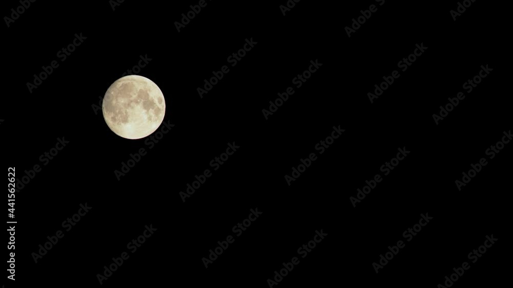 Movement of the full round moon at night in a clear dark sky without stars Movement of the full round moon at night in a clear dark sky without stars