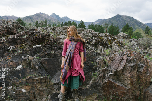 Beautiful woman wearing bright colored ethnic clothes in the mountains