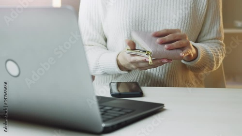 Online payments. Banking service. Mobile app. Transfer operation. Unrecognizable woman taking plastic card from wallet typing verification number in smartphone light room interior. photo