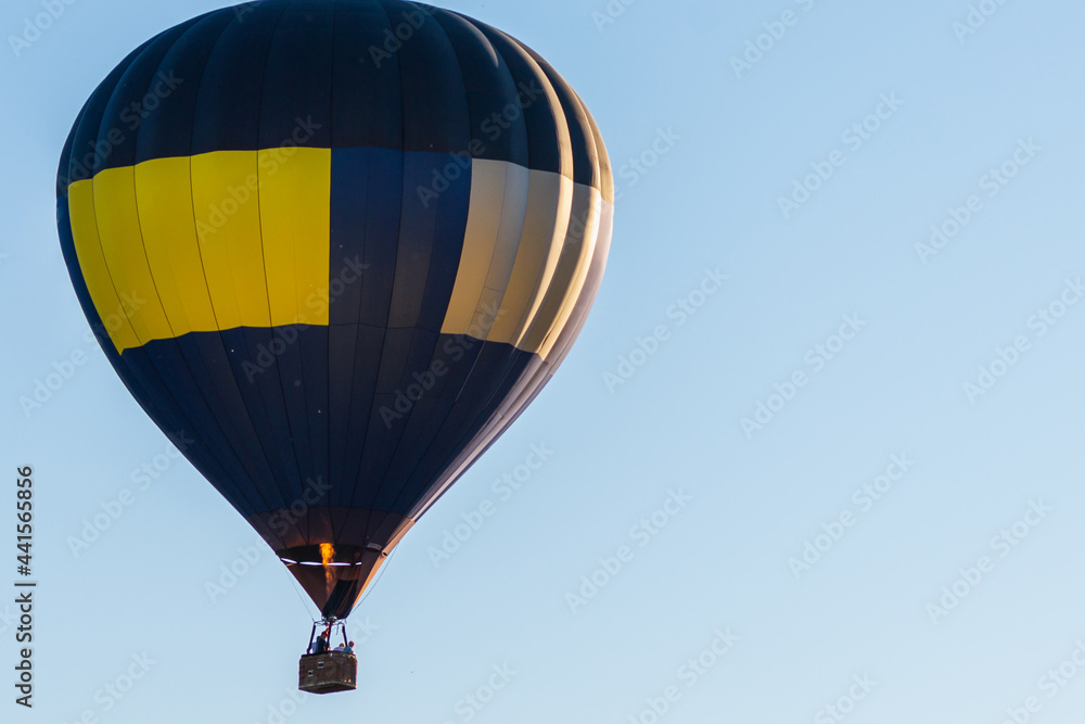 Obraz premium Hot Air Balloon on a blue sky.One Blue yellow hot air balloon in blue clear sky.Copy space.