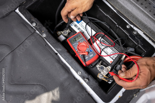 Starter battery getting checked with a multimeter 