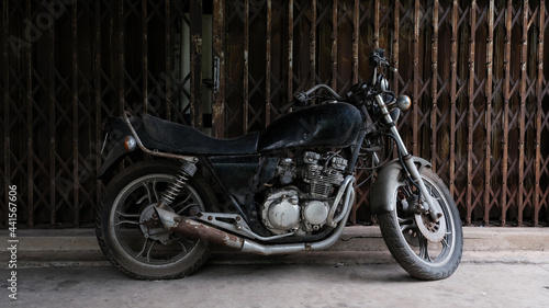 Vintage motorcycle parking near ancient door house.