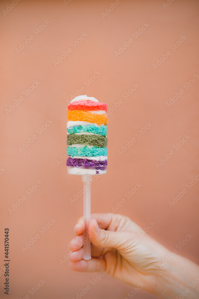 Hand holding tasty rainbow cake Hand holding tasty rainbow cake