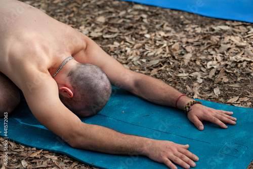 Doing yoga in the woods. Stretching on a exercise mat. photo