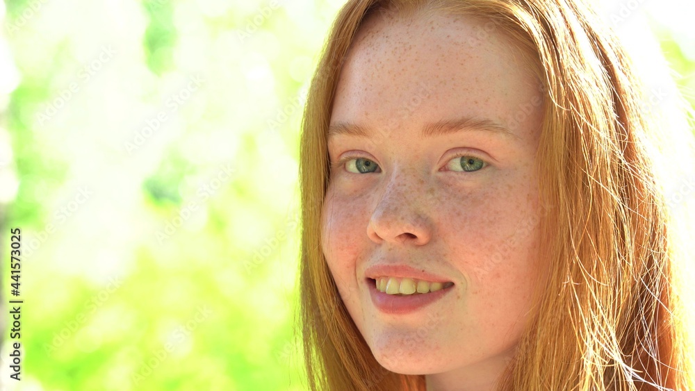 Portrait a smiling young woman with red hair and freckles against the backdrop of a bright sunny meadow. Natural beauty with freckles Portrait a smiling young woman with red hair and freckles against the backdrop of a bright sunny meadow. Natural beauty with freckles
