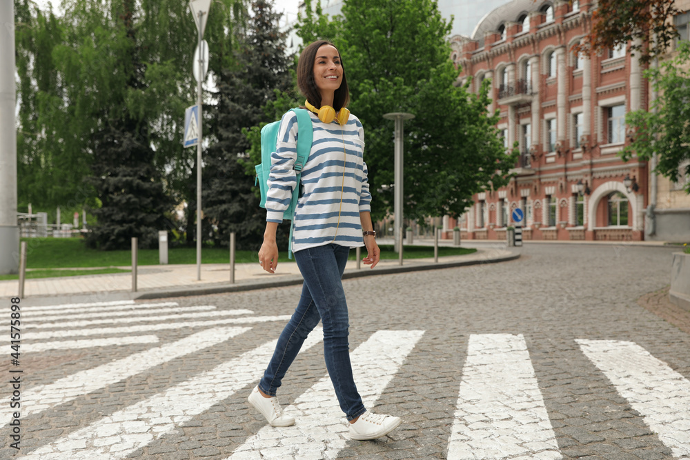Young woman crossing street. Traffic rules and regulations Young woman crossing street. Traffic rules and regulations